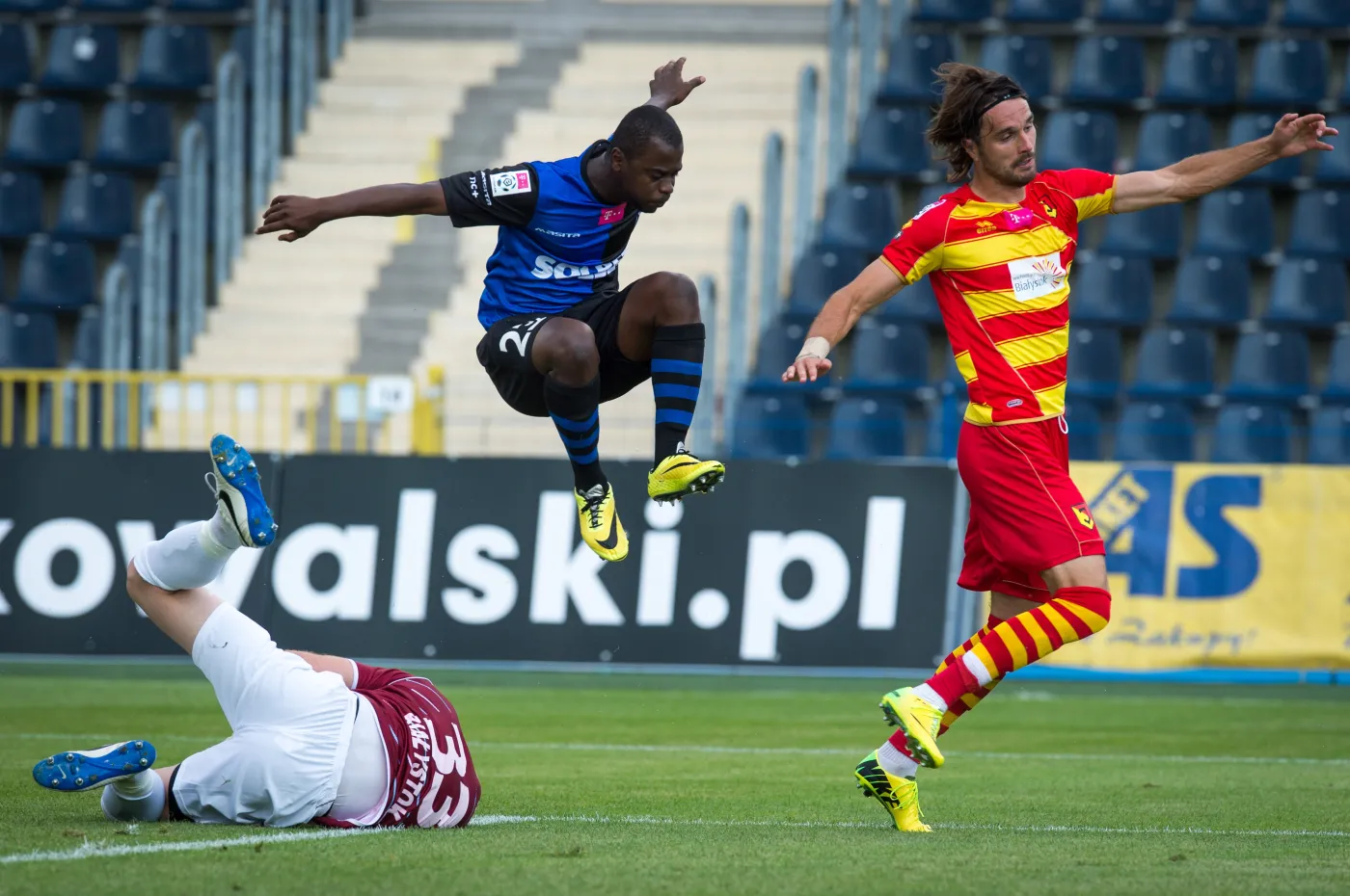 Piłkarz Zawiszy Bydgosz Jorge Paulo Alves Kadu (C) przelatuje nad bramkarzem Jagiellonii Białystok Krzysztofem Baranem (L) podczas meczu polskiej Ekstraklasy, 27 bm. Z prawej Sebastian Madera