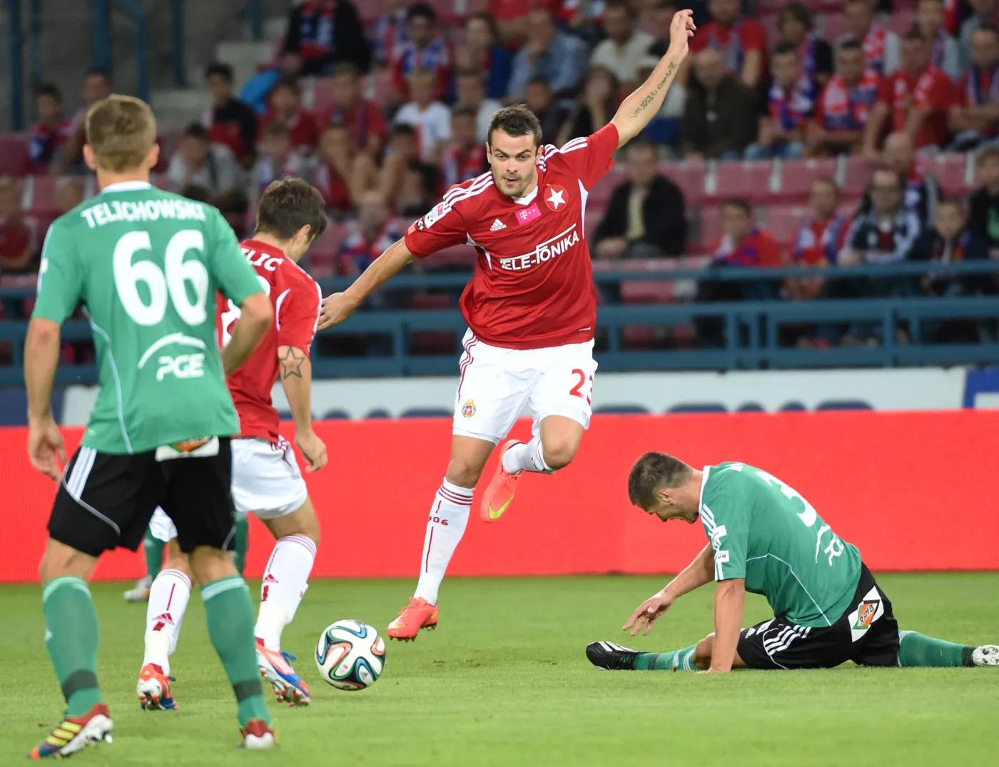Zawodnicy Wisły Kraków Paweł Brożek (C) i Semir Stilić (2L) oraz Błażej Telichowski (L) i Grzegorz Baran (P) z PGE GKS Bełchatów 