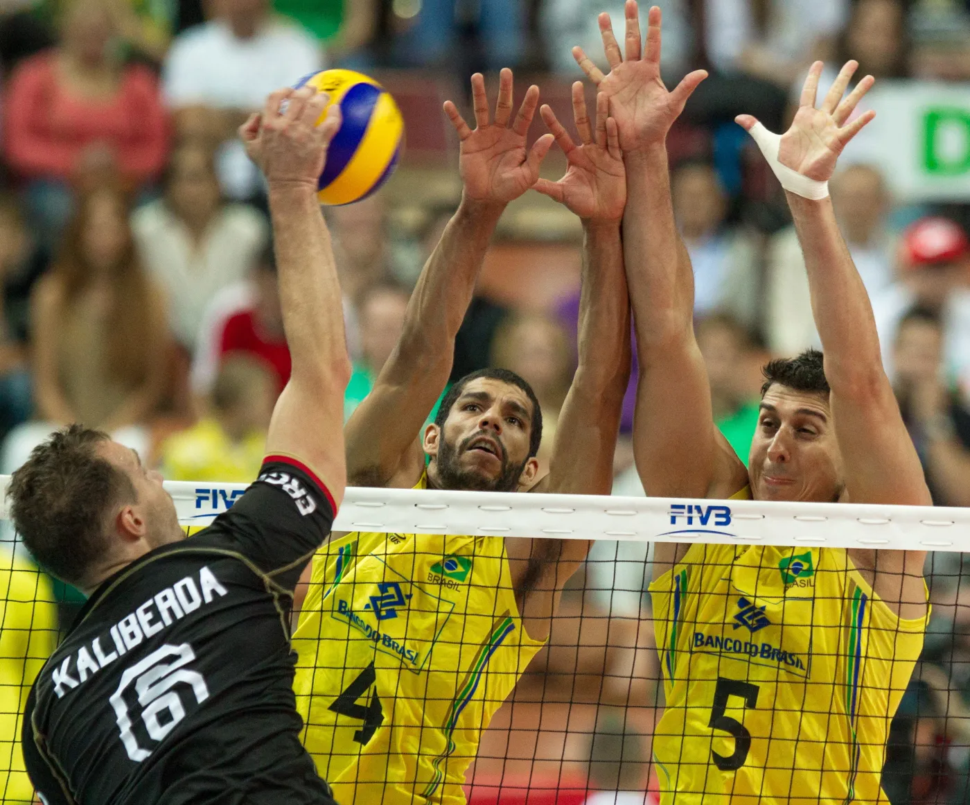 Piłkę zbija atakujący Niemiec Denys Kaliberda, blokują po drugiej stronie siatki Brazylijczycy Wallace De Souza (C) i Sidnei Dos Santos (P) w meczu grupy B mistrzostw świata siatkarzy w Katowicach