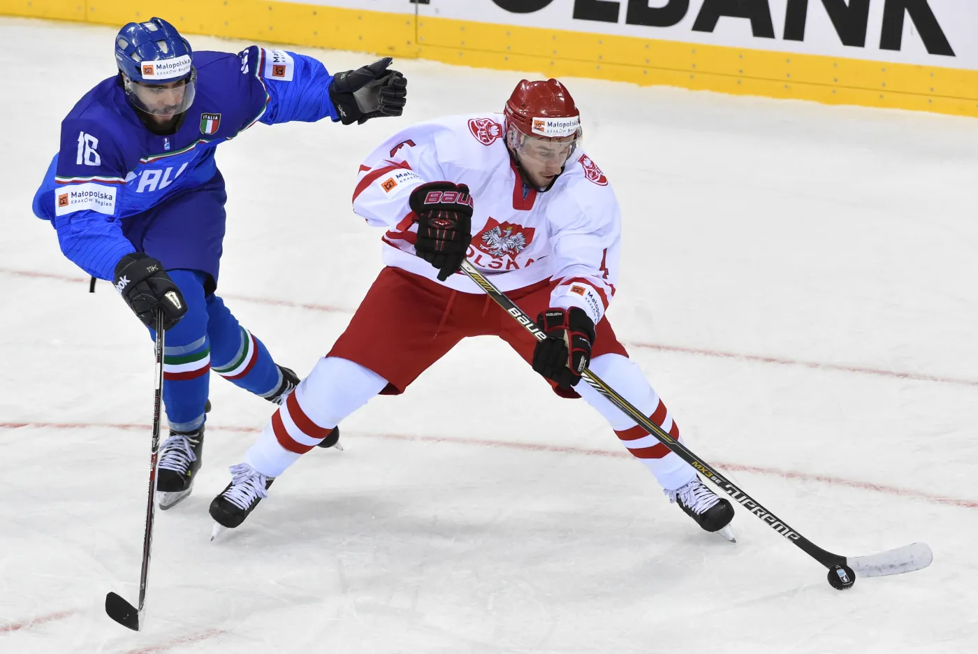 Polak Patryk Wajda (P) walczy o krążek z Włochem Giovannim Morinim (L) podczas meczu hokejowych mistrzostw świata dywizji 1A w Krakowie
