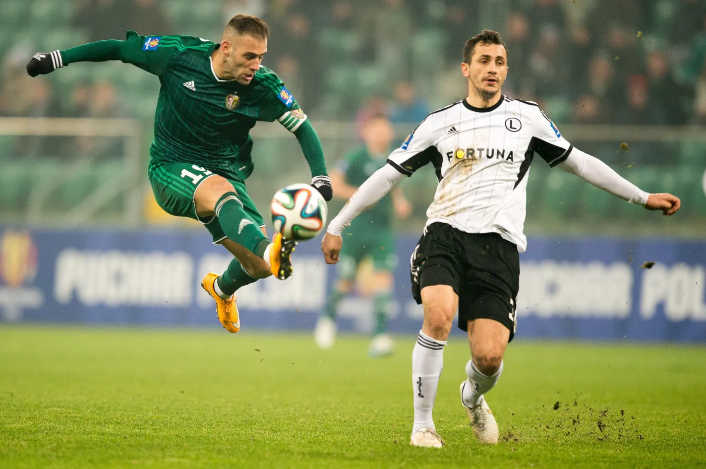 W akcji do piłki Marco Paixao (L) z miejscowego Śląska obok Tomasza Jodłowca (P) z Legii Warszawa w pierwszym meczu 1/4 finału Pucharu Polski we Wrocławiu