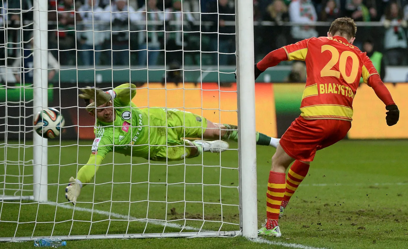 Piłkarz Jagiellonii Białystok Maciej Gajos (P) pokonuje bramkarza Legii Warszawa Arkadiusza Malarza (L) podczas meczu polskiej Ekstraklasy