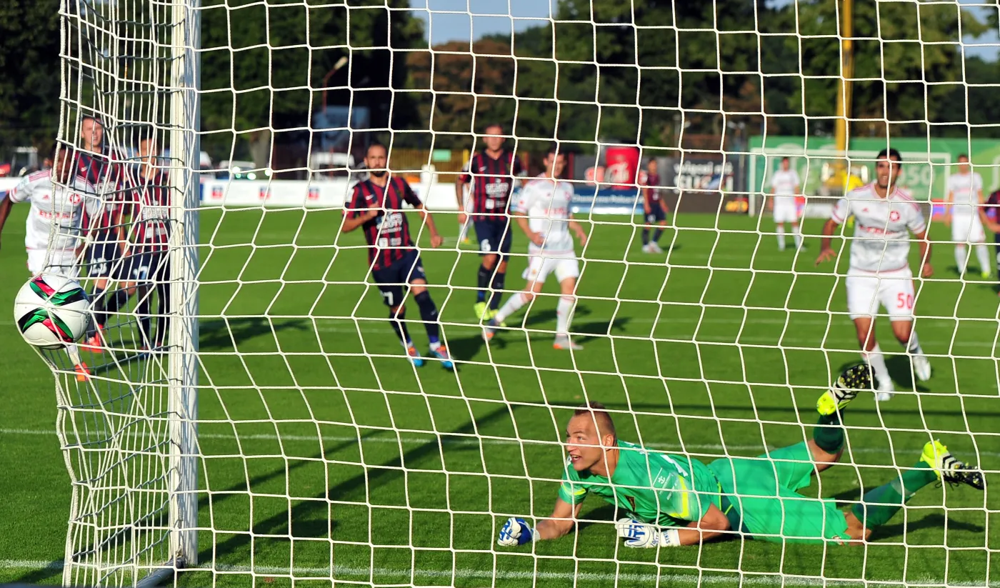 Piłkarz Wisły Kraków Rafael Crivellaro (P,w głębi) pokonuje z rzutu karnego Dawida Kudłę (C) z Pogoni Szczecin podczas meczu polskiej Ekstraklasy