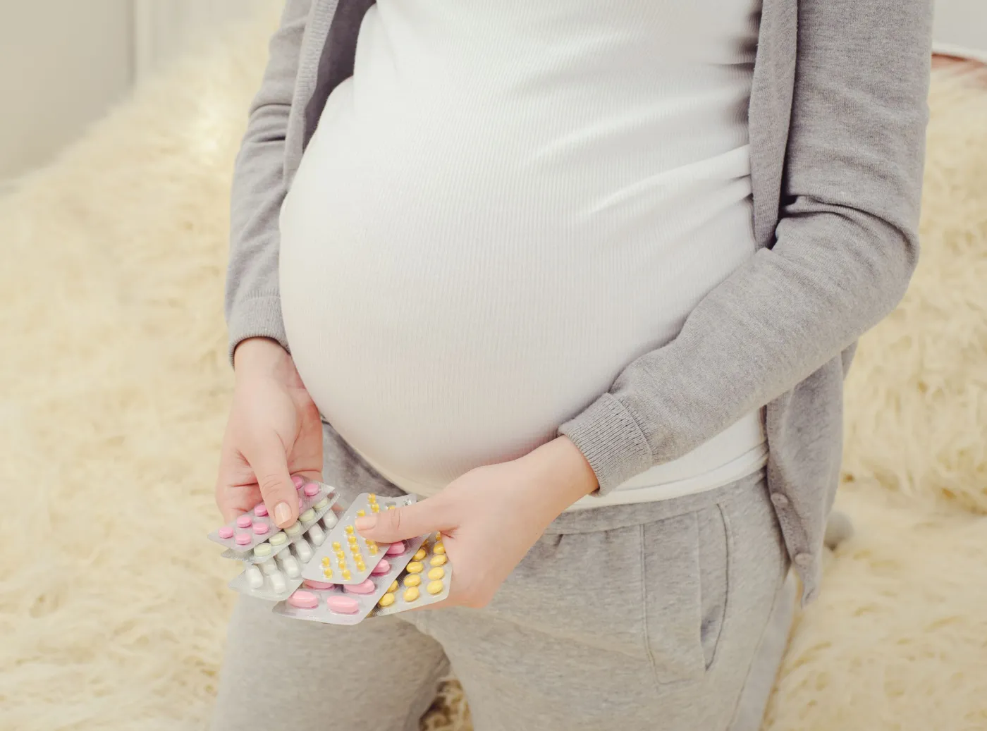 Kobieta w ciąży trzyma leki