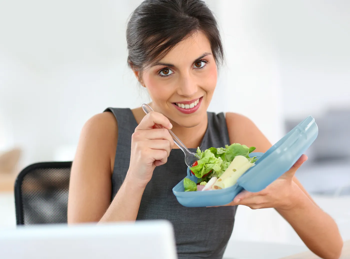 Kobieta je lunch przy biurku