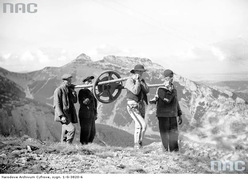 Transport części składowych roboczej kolejki linowej - koło zębate wyciągarki. W głębi widok na Giewont od strony południowej.