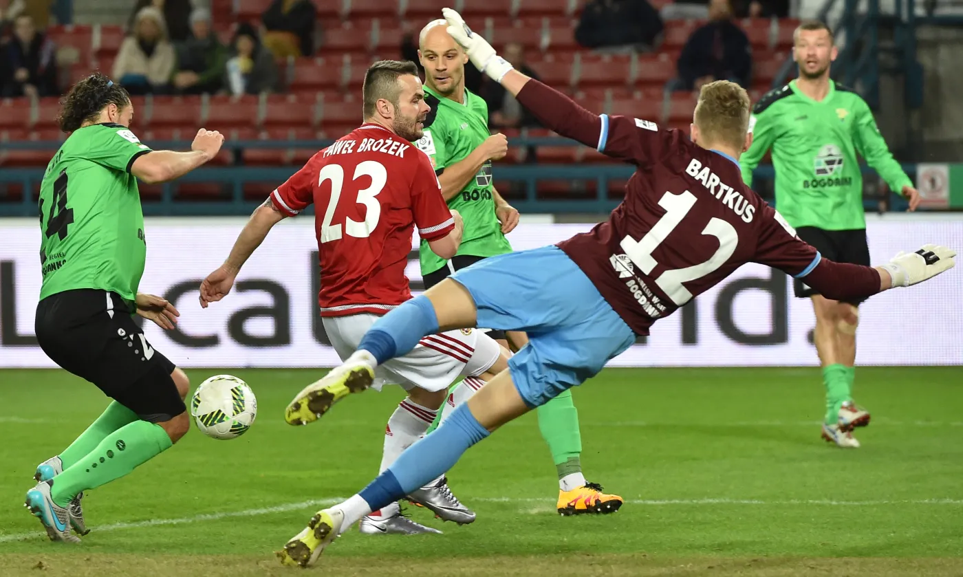 Zawodnik Wisły Kraków Paweł Brożek (2-L) naciera na bramkarza Górnika Łęczna Dżiugalasa Bartkusa (C-P)