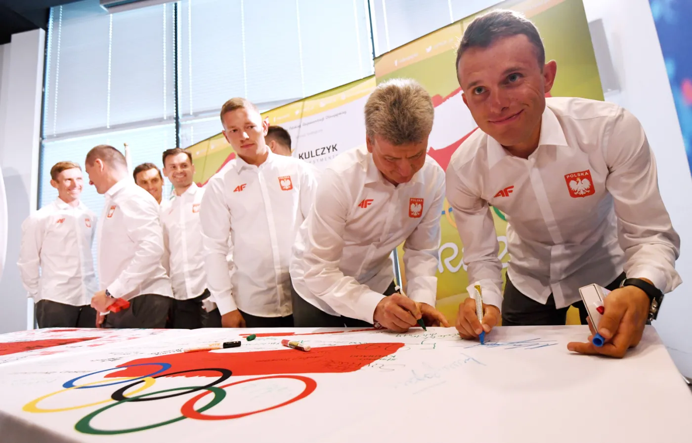 Rafał Majka składa podpis na fladze Polskiego Komitetu Olimpijskiego