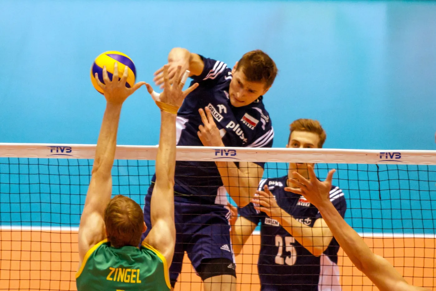 Piotr Nowakowski (C) atakuje po bloku Australijczyka Aidana Zingela (L) w ostatnim meczu interkontynentalnego turnieju kwalifikacyjnego do Igrzysk Olimpijskich w Rio