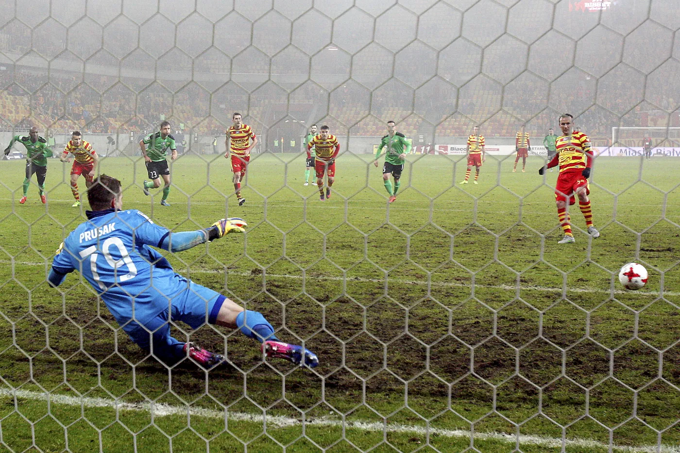 Piłkarz Jagiellonii Białystok Konstantin Vassiljev (P) pokonuje z rzutu karnego Sergiusza Prusaka (L) z Górnika Łęczna