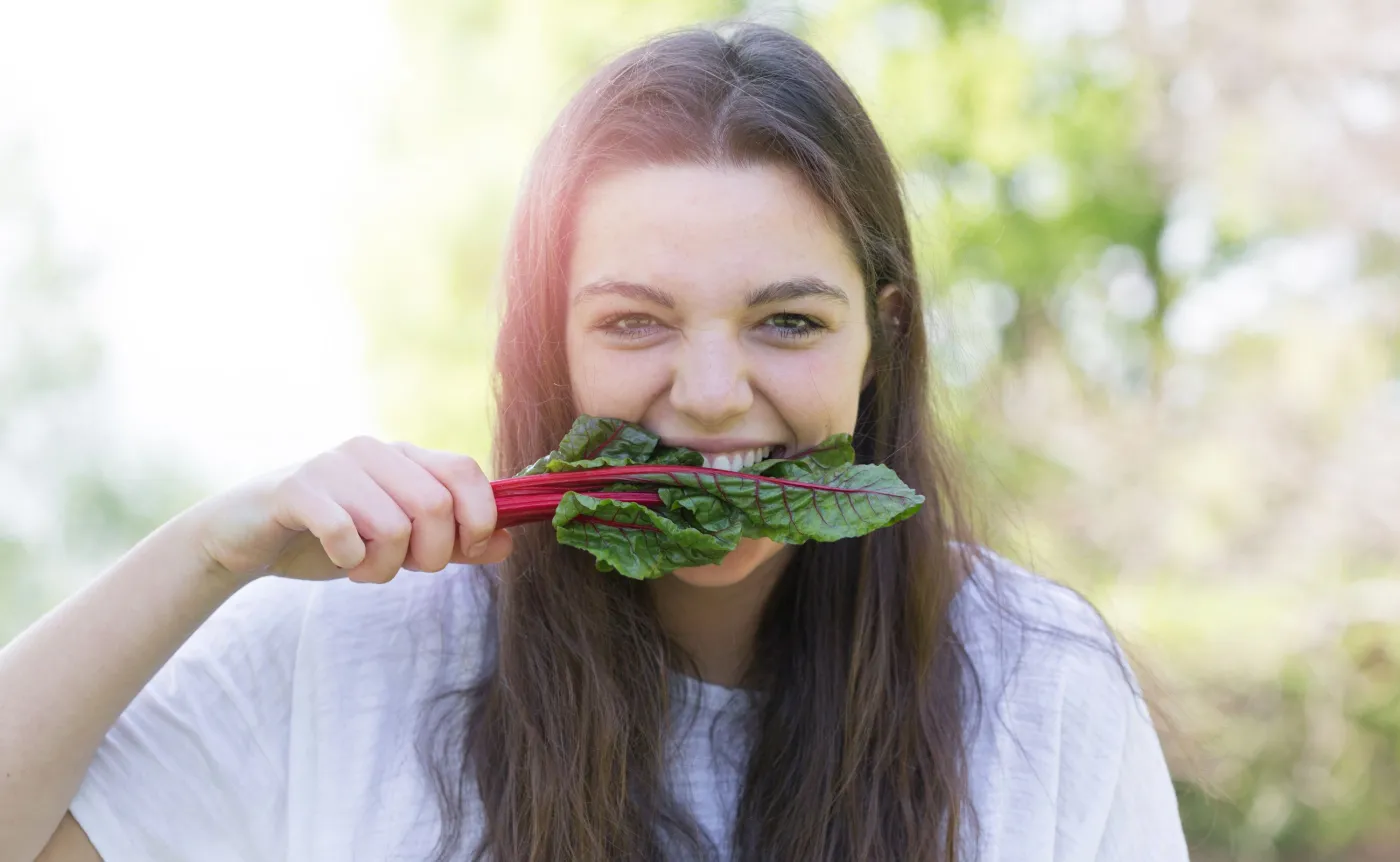 Kobieta gryzie liście buraka