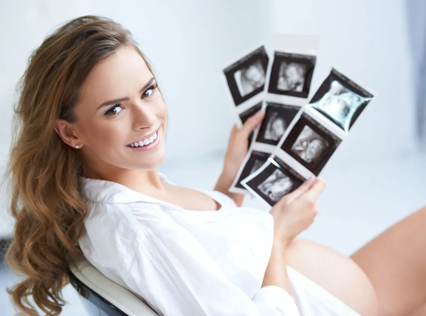 Kobieta w ciąży trzyma wyniki badania USG