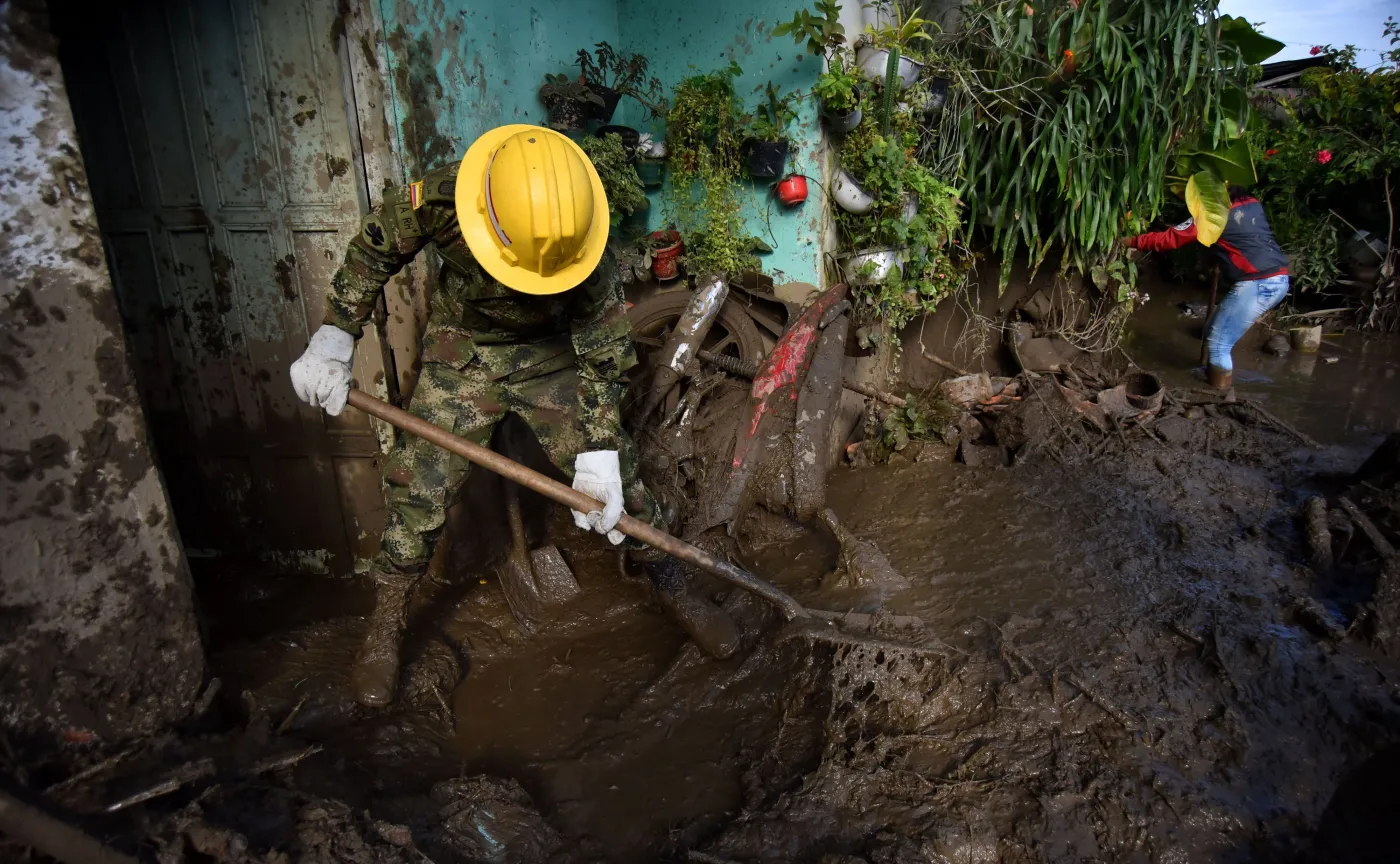 Żołnierz usuwa skutki lawiny błotnej w Kolumbii w roku 2017