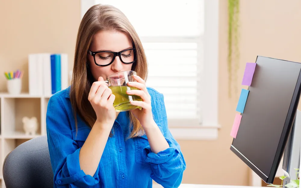 Kobieta pije zieloną herbatę