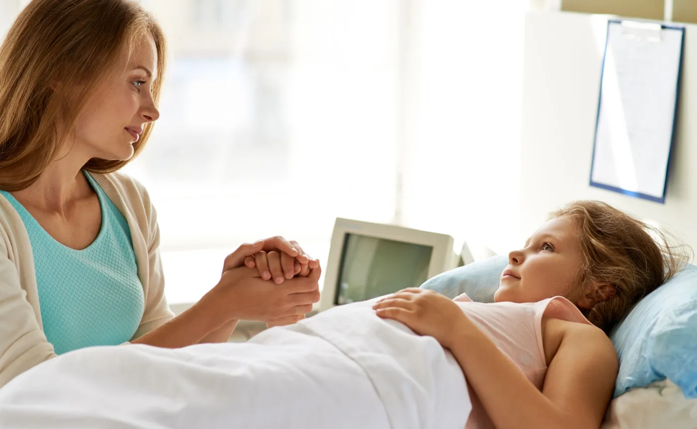 Kobieta przy łóżku dziecka w szpitalu