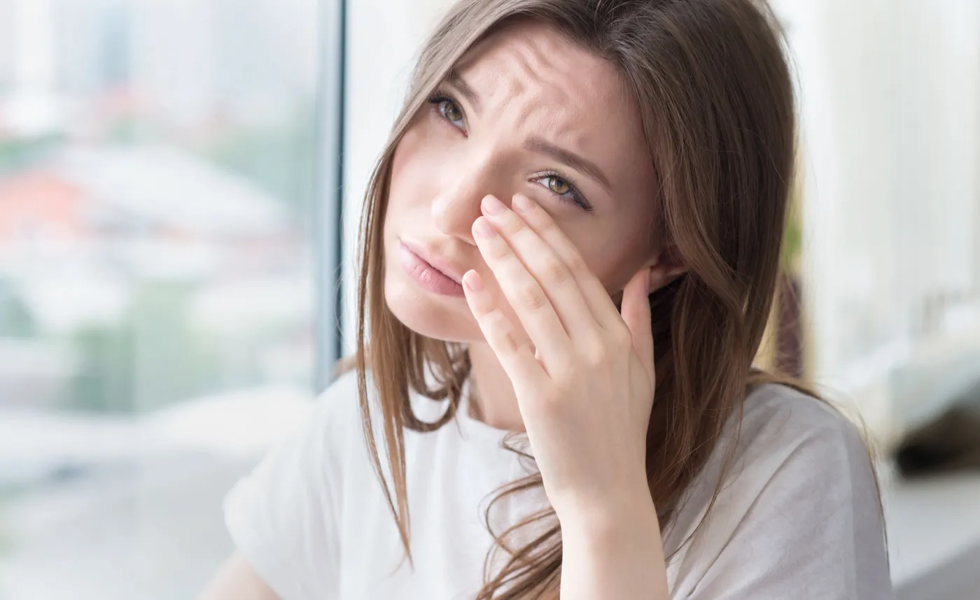 Kobieta przeciera oczy, łzy