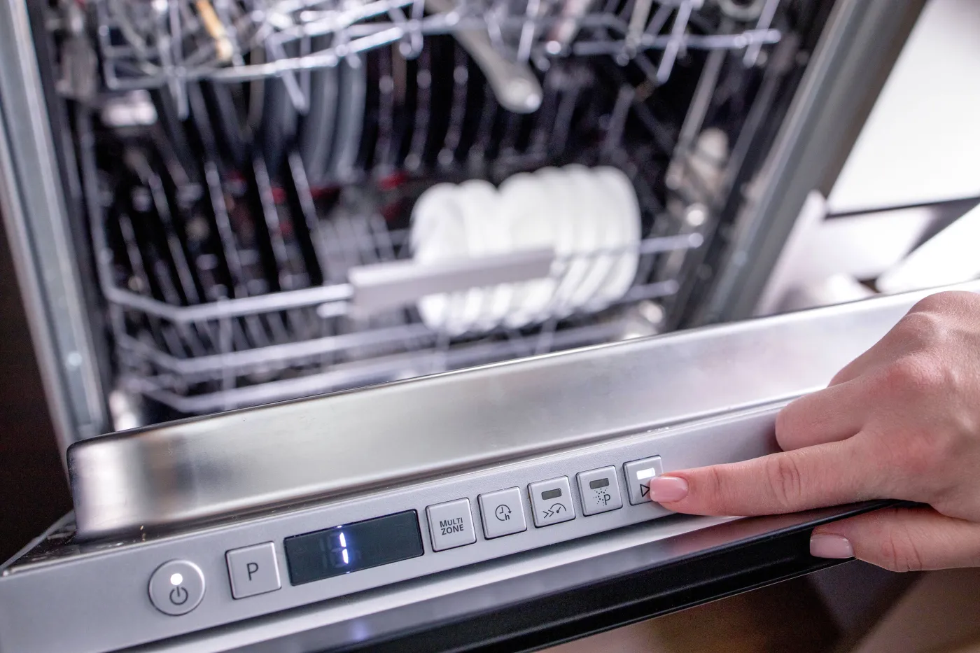 Woman's,Hand,Turns,On,The,Dishwasher,To,Wash,The,Dishes.