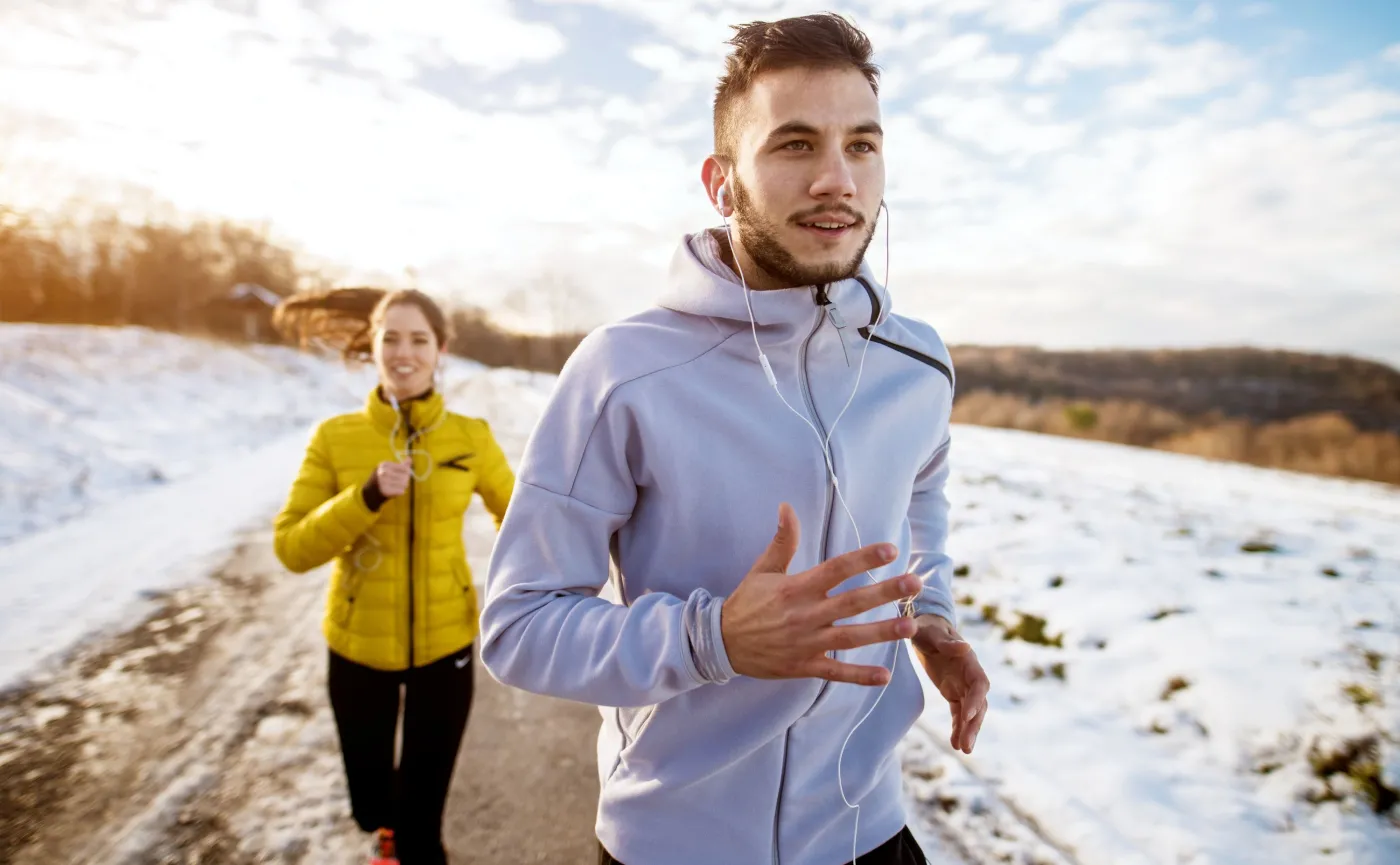 Kobieta z mężczyzną biegają zimą