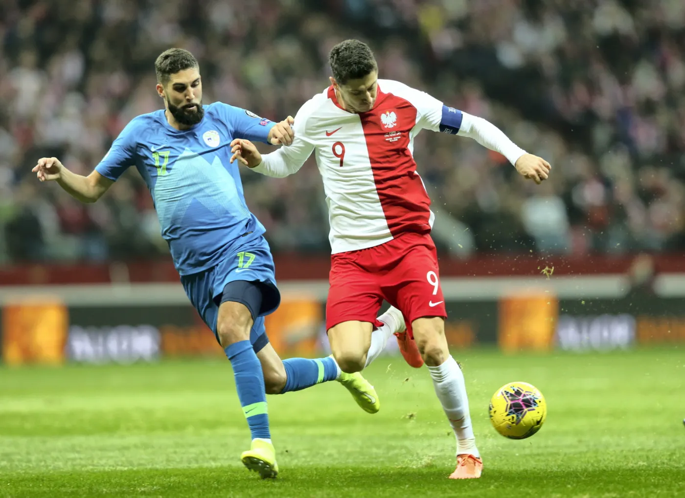 Polak Robert Lewandowski (P) i Miha Mevlja (L) ze Słowenii podczas meczu eliminacyjnego piłkarskich mistrzostw Europy na PGE Narodowy w Warszawie