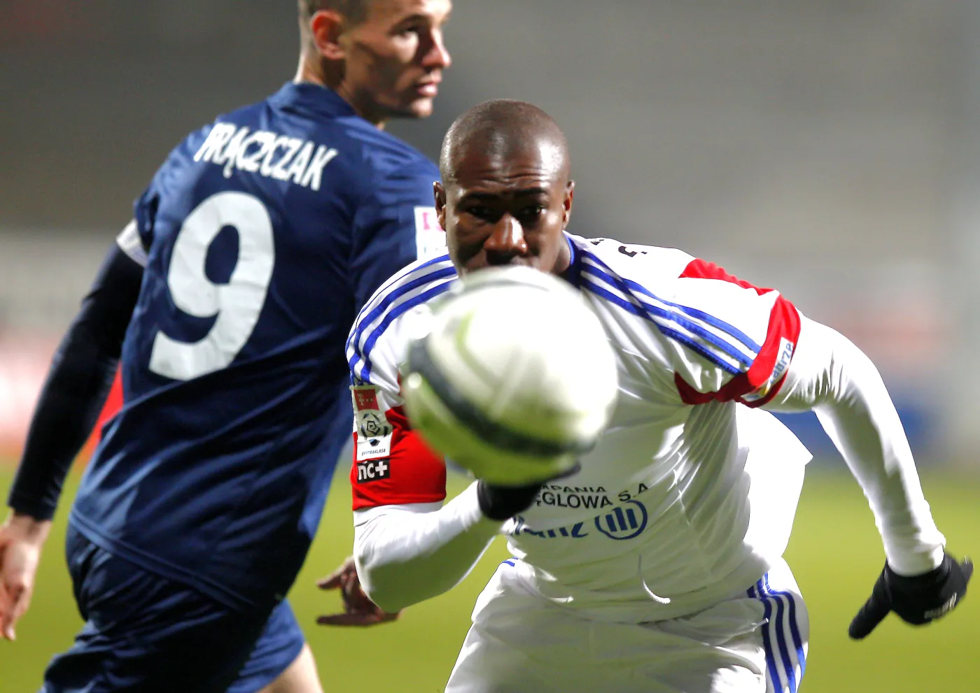 Zawodnik Górnika Zabrze Prejuce Nakoulma (P) walczy o piłkę z Adamem Frączczakiem (L) z Pogoni Szczecin