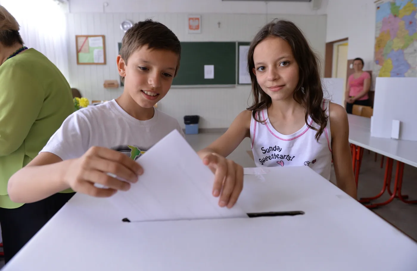 Referendum w sprawie ogranizacji igrzysk w Krakowie. Dzieci pomagają rodzicom wrzucić głos do urny