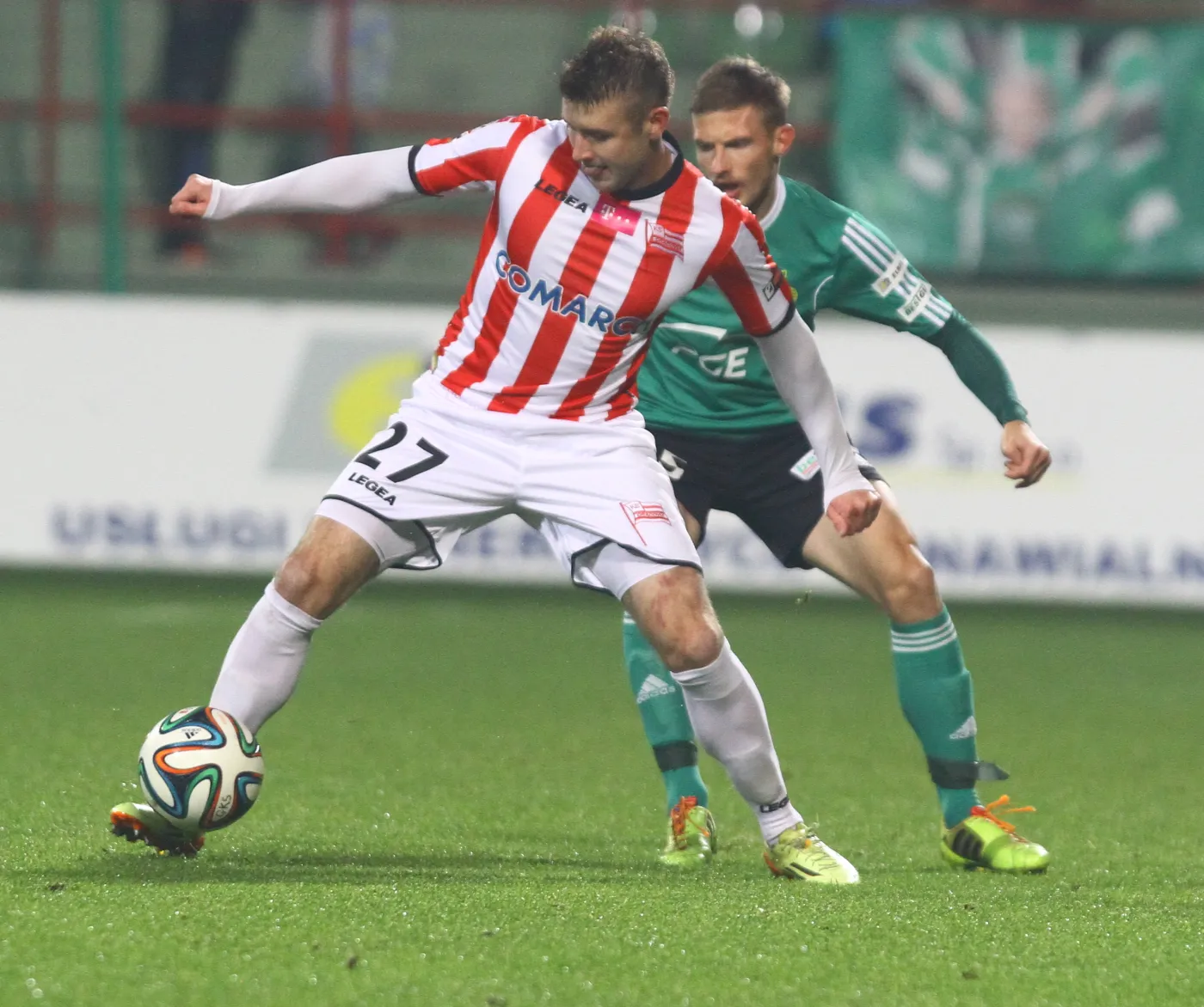 W akcji z piłką Marcin Budziński (L) z Cracovii przed Adamem Mójtą (P) z miejscowego GKS w meczu T-Mobile Ekstraklasy