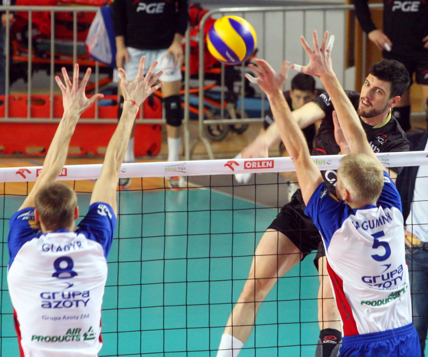 Piłkę zbija atakujący po drugiej stronie siatki Facundo Conte z PGE Skra Bełchatów, blokują Jurij Gladyr (L) i Paweł Zagumny (P) z miejscowej ZAKSY 