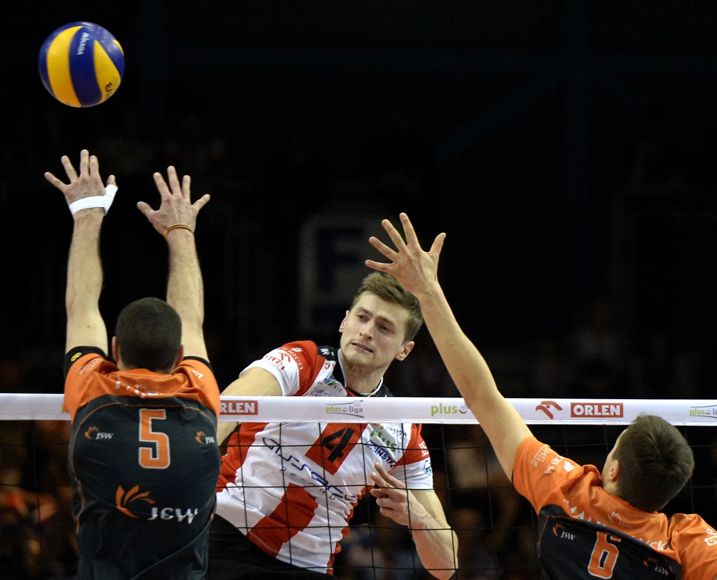 Zawodnik Asseco Resovii Rzeszów Piotr Nowakowski (C) atakuje po bloku Alena Pajenka (L) i Mateusza Malinowskiego (P) z Jastrzębskiego Węgla podczas pierwszego meczu półfinałowego 