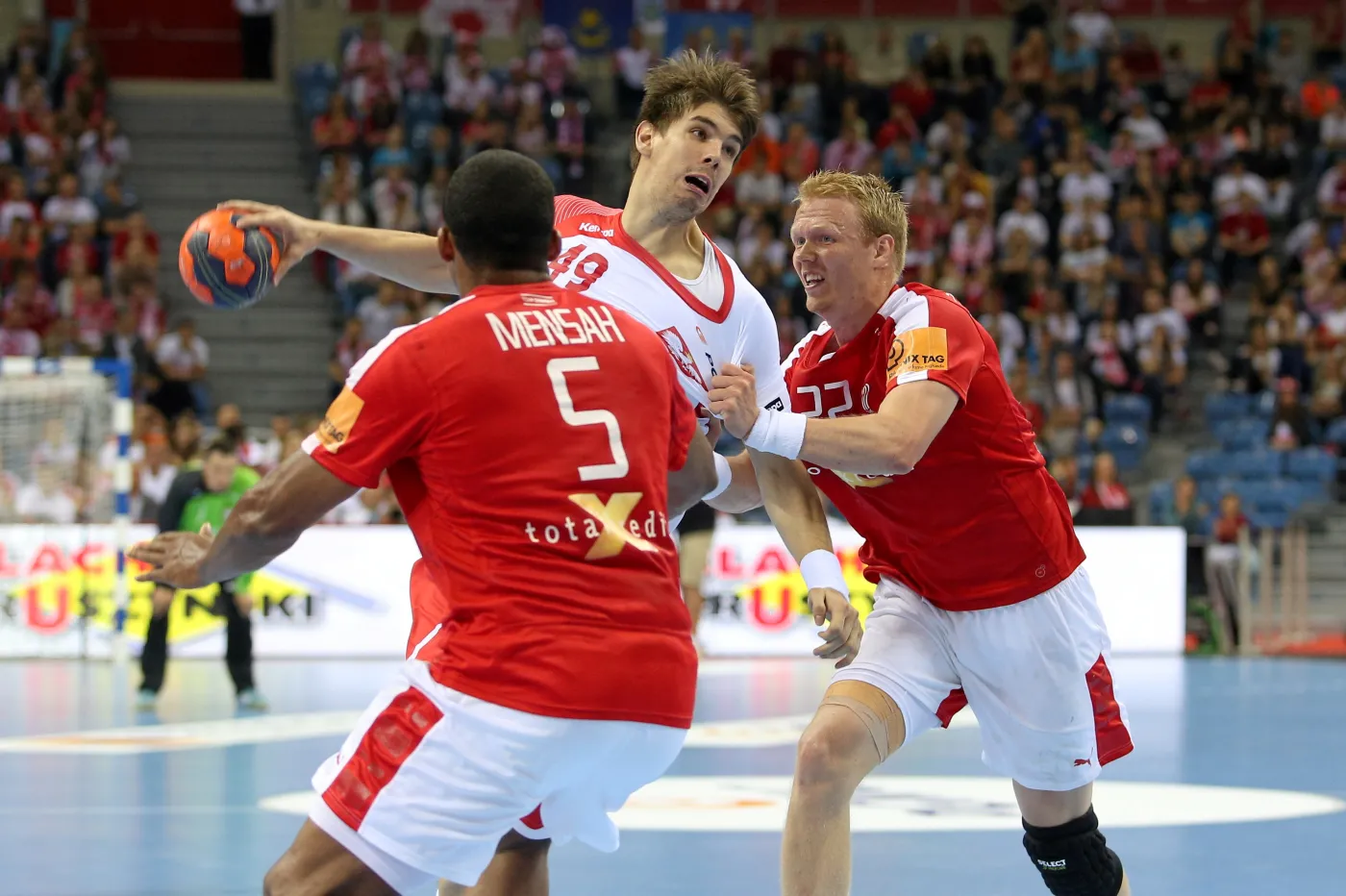 Polak Piotr Chrapkowski (C) mija Duńczyków Madsa Mensaha Larsena (L) i Andersa Zachariassena (P) podczas meczu towarzyskiego w Krakowie