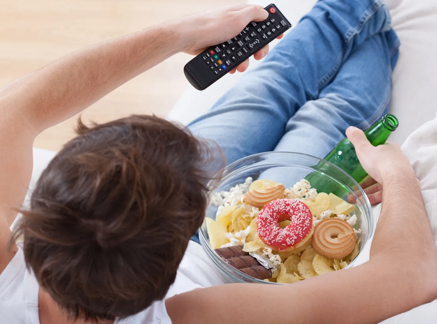 Mężczyzna je przekąski podczas oglądania TV