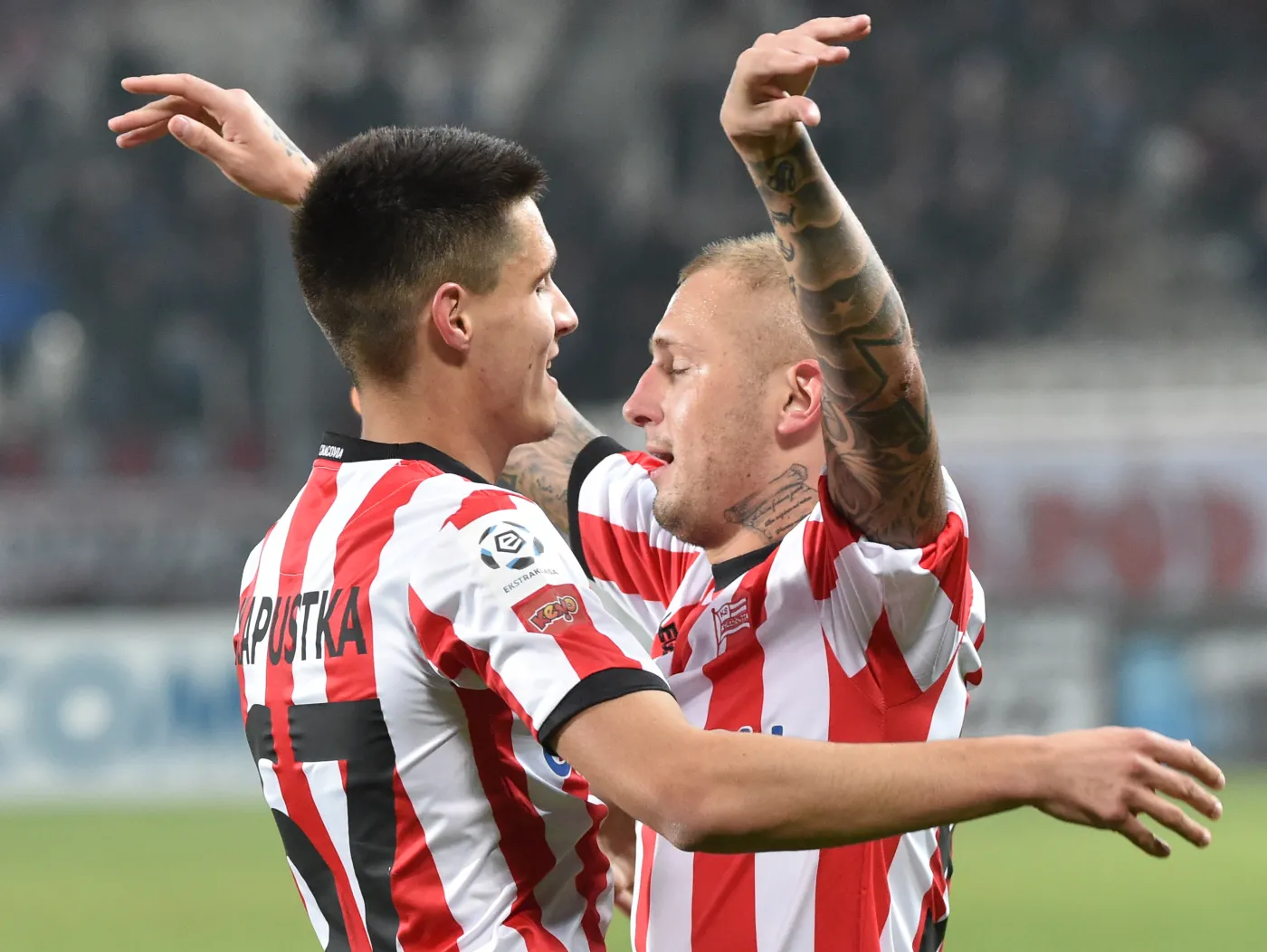 Zawodnicy Cracovii Deniss Deniss Rakels (P) i Bartosz Kapustka (L) cieszą się z bramki strzelonej drużynie Podbeskidzia Bielsko-Biała