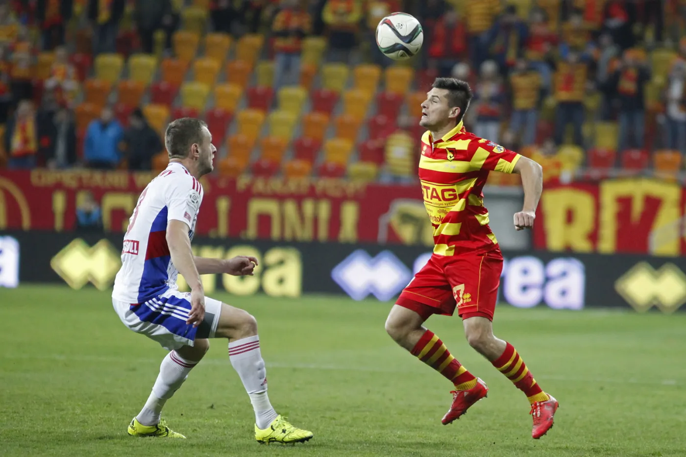 Zawodnik Jagiellonii Białystok Piotr Tomasik (P) walczy o piłkę z Mateuszem Słodowym (L) z Górnika Zabrze