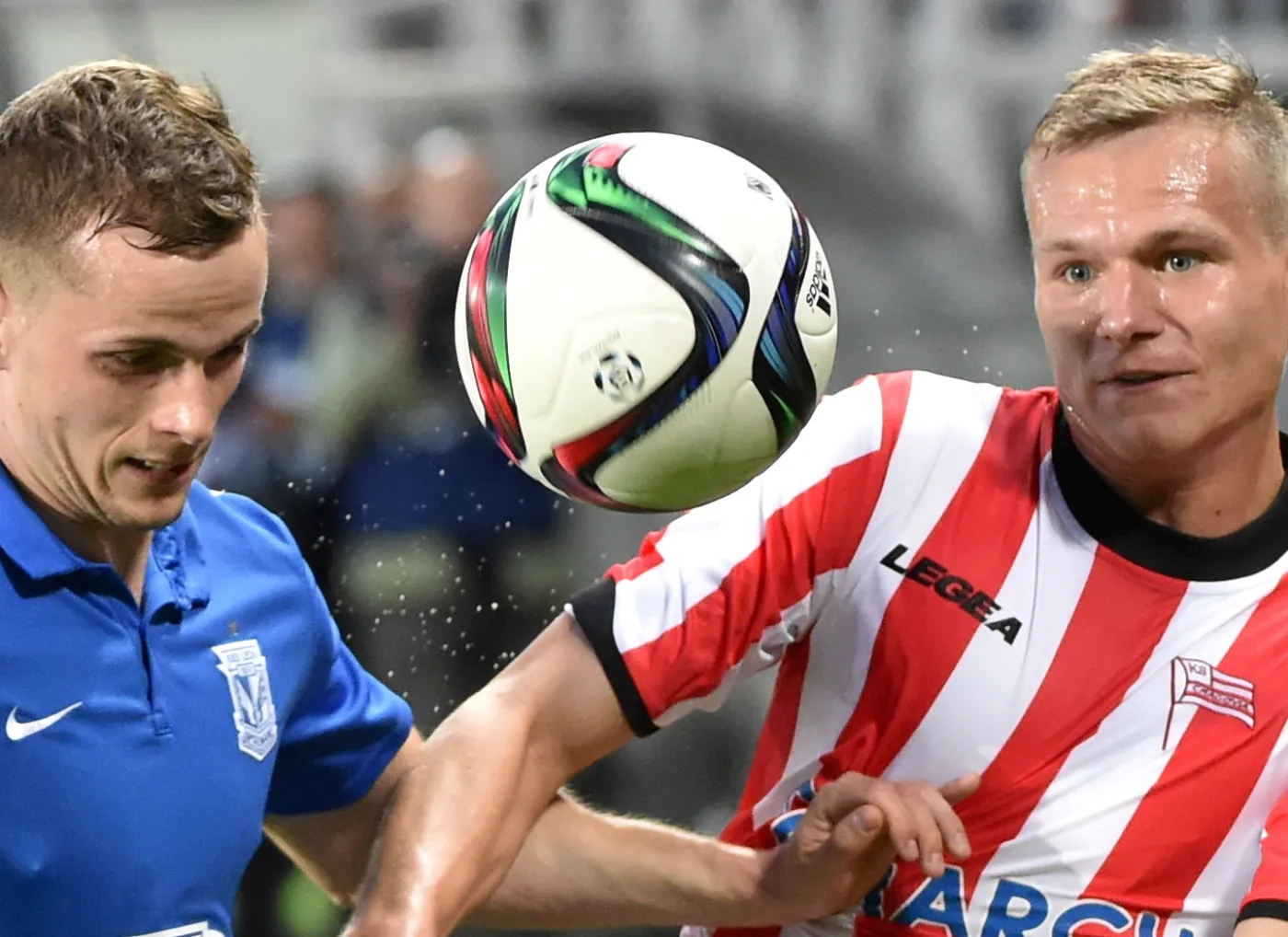 Zawodnik Cracovii Kraków Paweł Jaroszyński (P) walczy o piłkę z Tomaszem Kędziorą (L) z Lecha Poznań podczas meczu polskiej Ekstraklasy