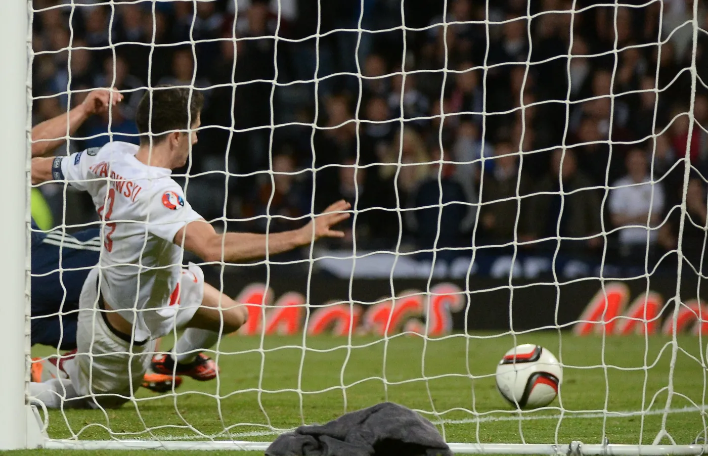 Napastnik reprezentacji Polski Robert Lewandowski strzela swojego drugiego gola w ostatnich sekundach doliczonego czasu gry w meczu grupy D piłkarskich mistrzostw Europy 2016 ze Szkocją na Hampden Park w Glasgow