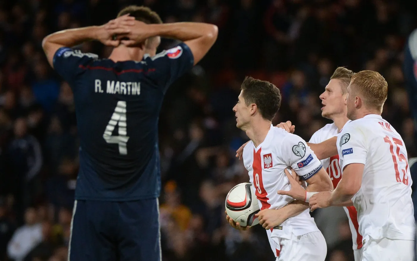 Napastnik reprezentacji Polski Robert Lewandowski (C) w towarzystwie partnerów z drużyny Łukasza Piszczka (2P) i Kamila Glika (P) po strzeleniu swojego drugiego gola w meczu grupy D piłkarskich mistrzostw Europy 2016 ze Szkocją na Hampden Park w Glasgow