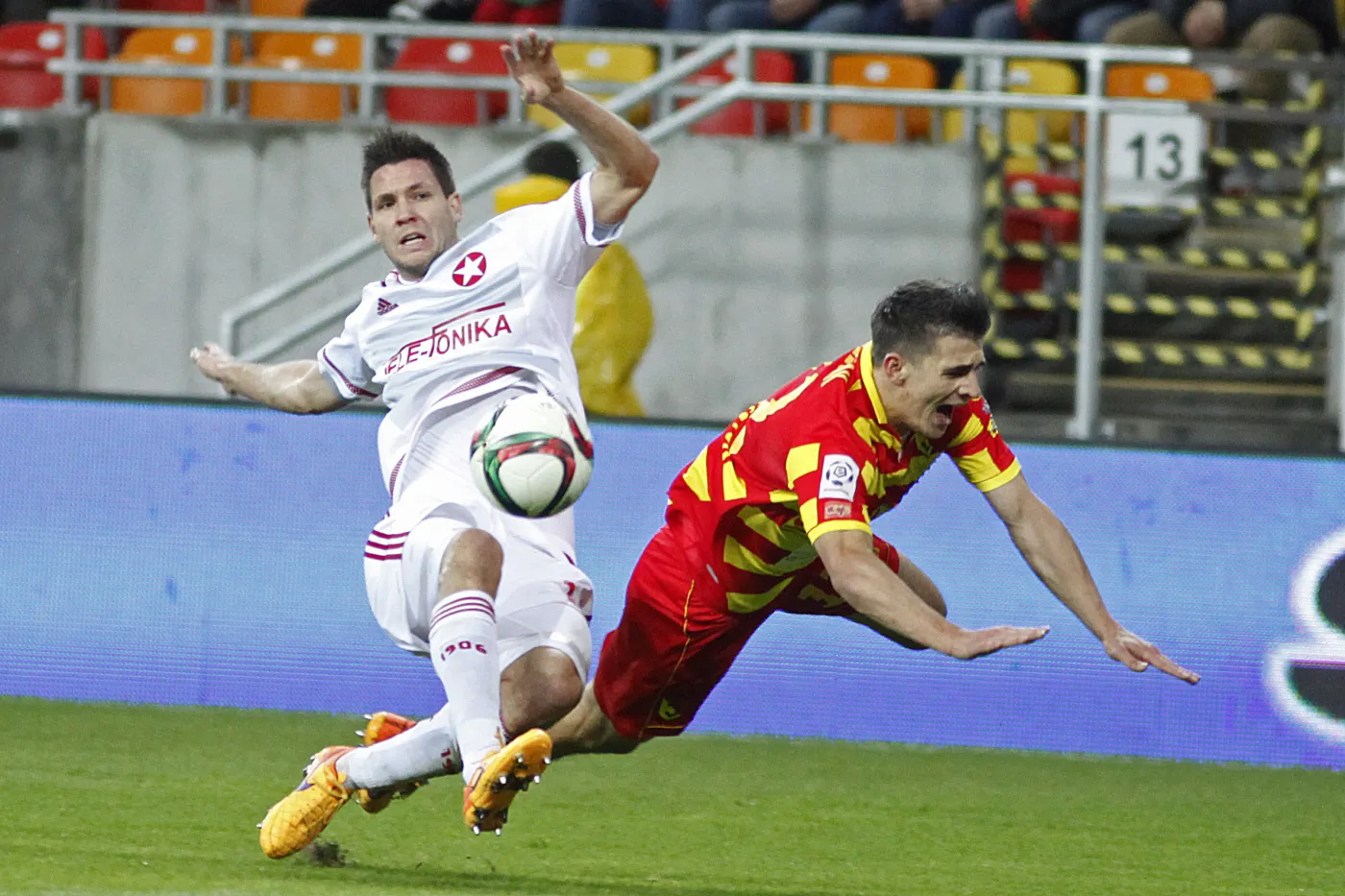 Zawodnik Jagiellonii Białystok Piotr Grzelczak (P) walczy o piłkę z Richardem Guzmicsem (L) z Wisły Kraków podczas meczu polskiej Ekstraklasy