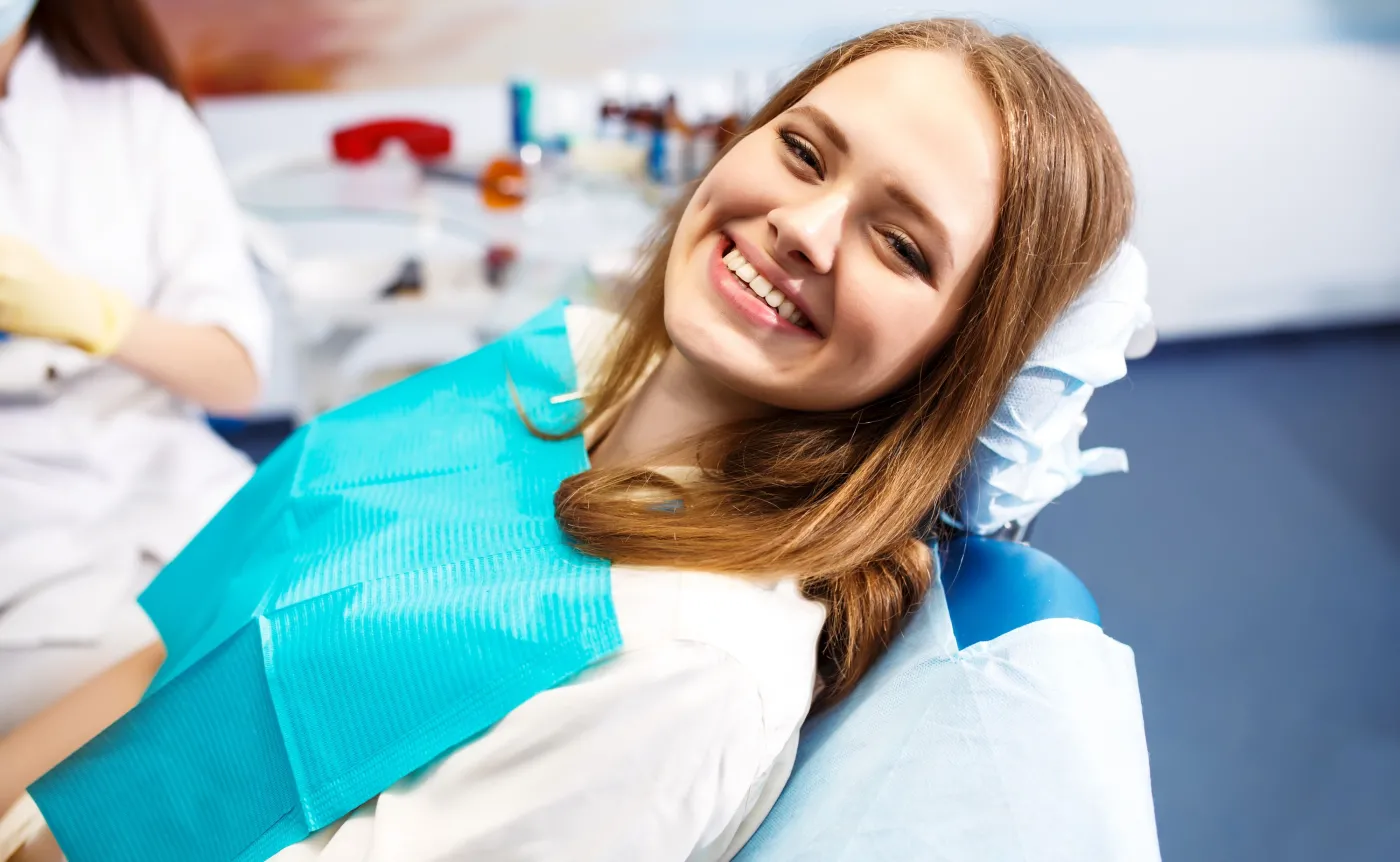 Uśmiechnięta kobieta na fotelu dentystycznym