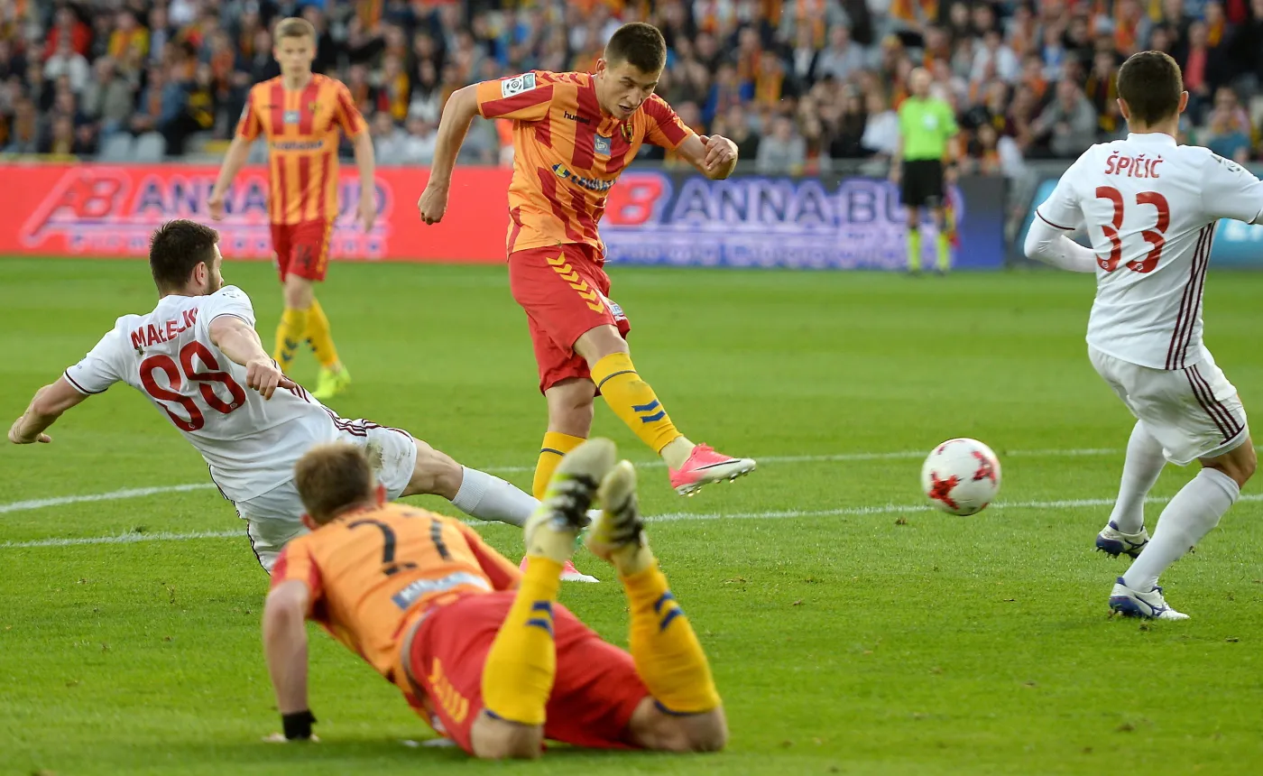 Piłkarz Korony Kielce Mateusz Możdżeń strzela drugą bramkę w meczu z Wisłą Kraków grupy mistrzowskiej pilkarskiej Ekstraklasy. Obok Piłkarze Wisły Kraków Patryk Małecki (L) i Matija Spicic (P)