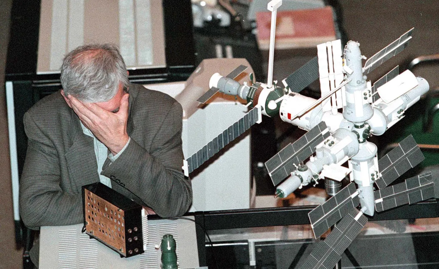 Wiktor Błagow, siedzi zmęczony obok makiety stacji orbitalnej Mir, po tym gdy w 1997 roku niespodziewanie odwołano kolejną próbę przycumowania statku dostawczego Progress do stacji orbitalnej Mir z powodu awarii komputera pokładowego Progressa