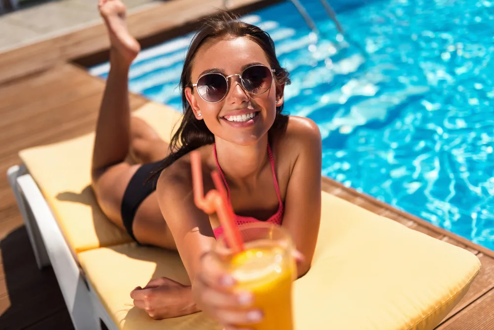 Kobieta z drinkiem nad basenie