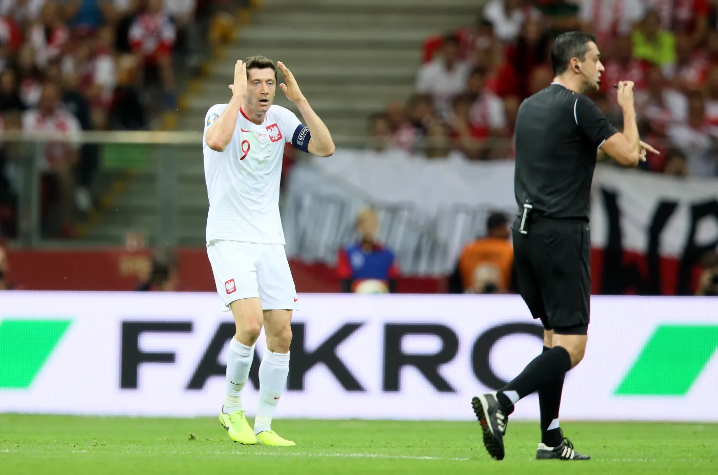 Robert Lewandowski (L) i sędzia Viktor Kassai (P) podczas meczu grupy G eliminacji piłkarskich mistrzostw Europy z Austrią