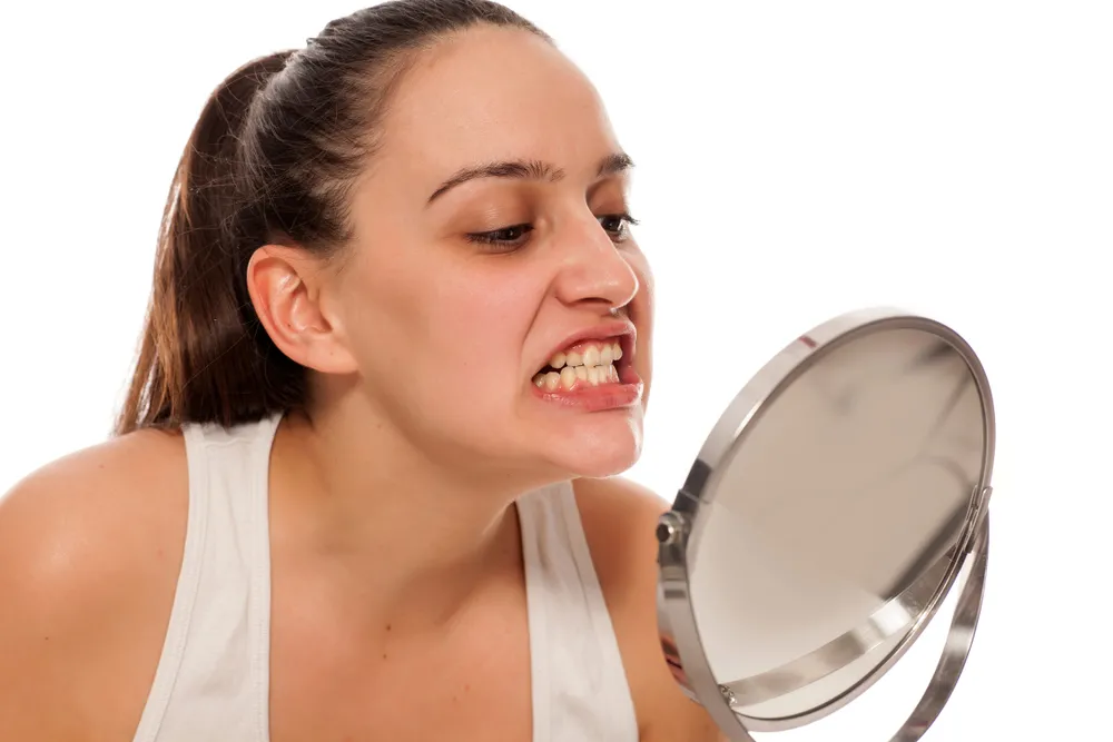 Kobieta ogląda swoje uzębienie w lutstrze