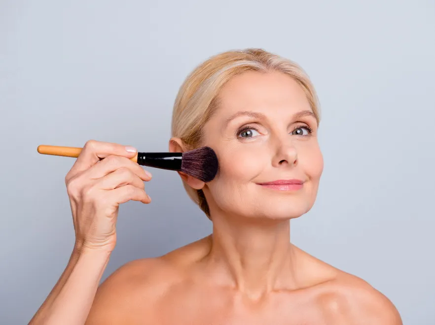 Dojrzała kobieta robi makijaż