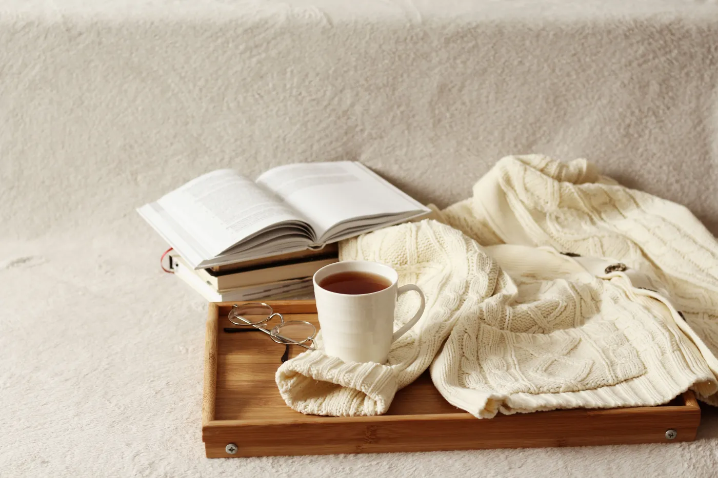 Knitted,Sweater,,Book,And,Cup,Of,Tea,On,A,Sofa.