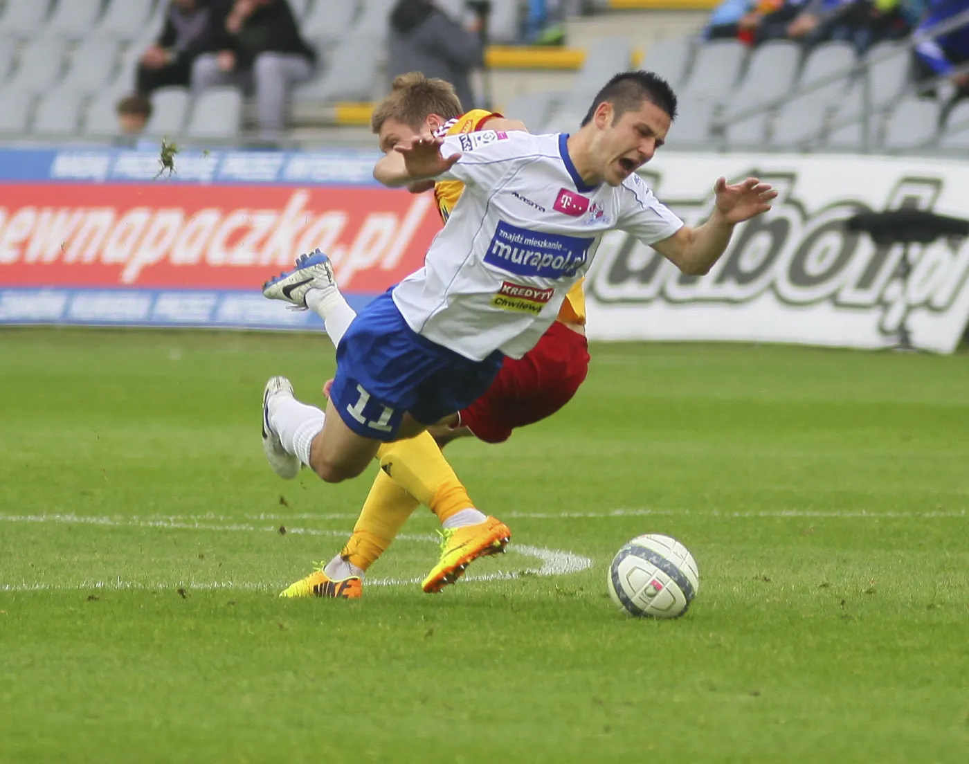 Zawodnik Korony Kielce (tył) podcina Antona Slobode z Podbeskidzia Bielsko-Biała podczas meczu grupy B piłkarskiej T-Mobile Ekstraklasy