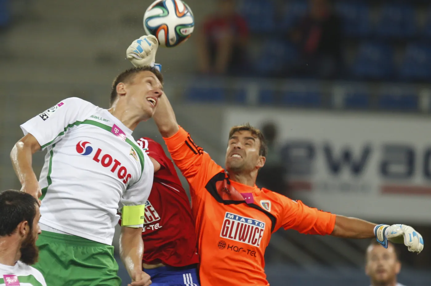 Interweniujacy bramkarz miejscowego Piasta Alberto Cifuentes (P) wypiąstkowuje piłkę uprzedzając atakującego Rafała Janickiego (L) z Lechii Gdańsk w meczu T-Mobile Ekstraklasy, rozegranym w Gliwicach