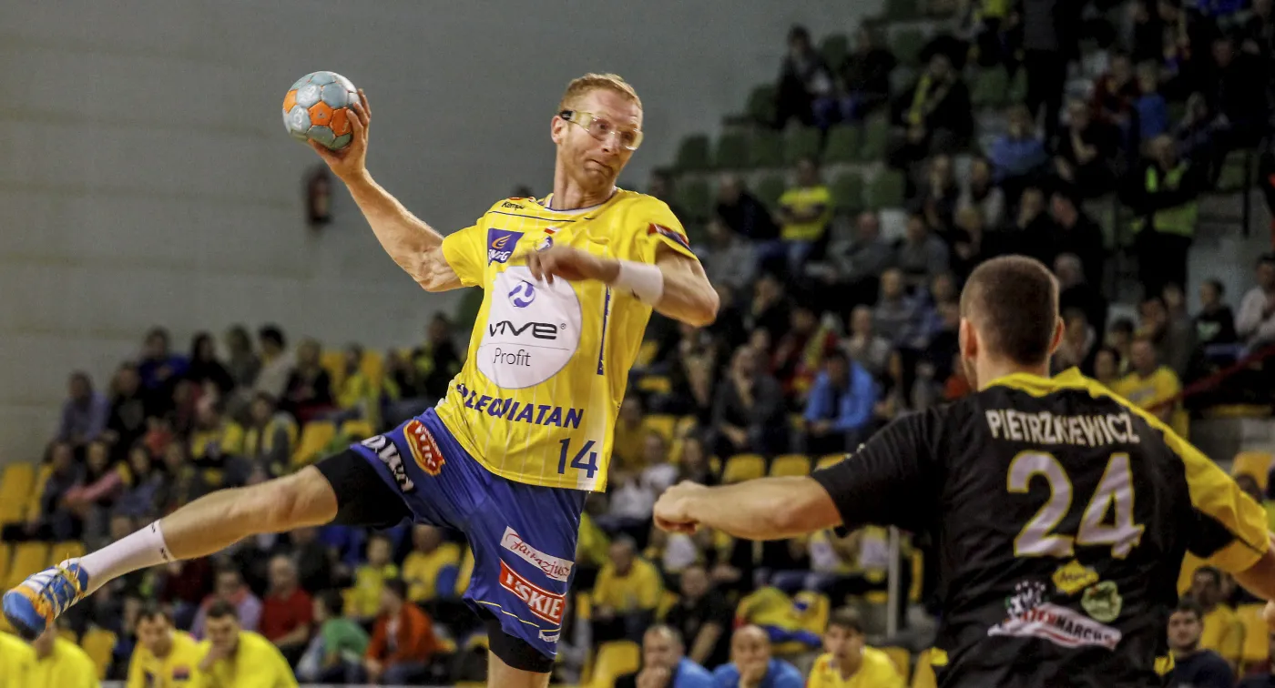 Zawodnik Vive Tauron Kielce Karol Bielecki (L) mija Dawida Pietrzkiewicza (P) z Nielby Wągrowiec