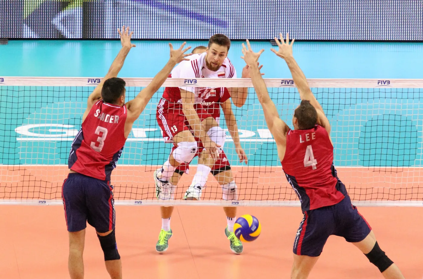 Reprezentant Polski Michał Kubiak (C) atakuje po bloku Tylora Sendera (L) i Davida Lee (P) z reprezentacji USA podczas meczu Ligi Światowej siatkarzy, Polska - USA, rozegranego w Tauron Arenie Kraków