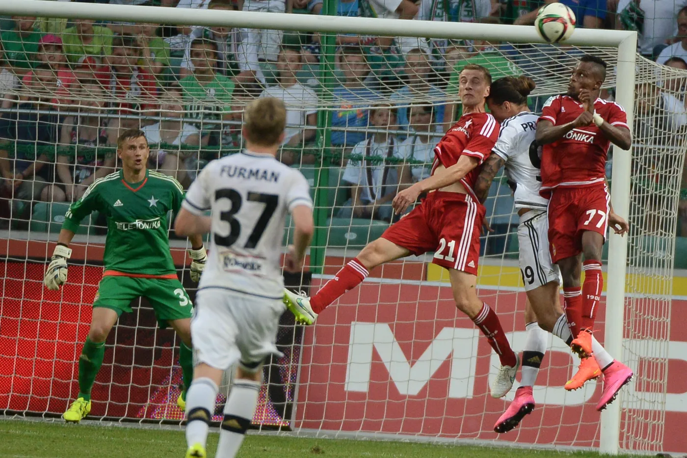 Zawodnik Legii Warszawa Aleksandar Prijovic (2-P) w kleszczach zawodników Wisły Kraków - Wilde-Donalda Guerriera (P) i Łukasza Burligi (3-P) podczas meczu polskiej T-Mobile Ekstraklasy