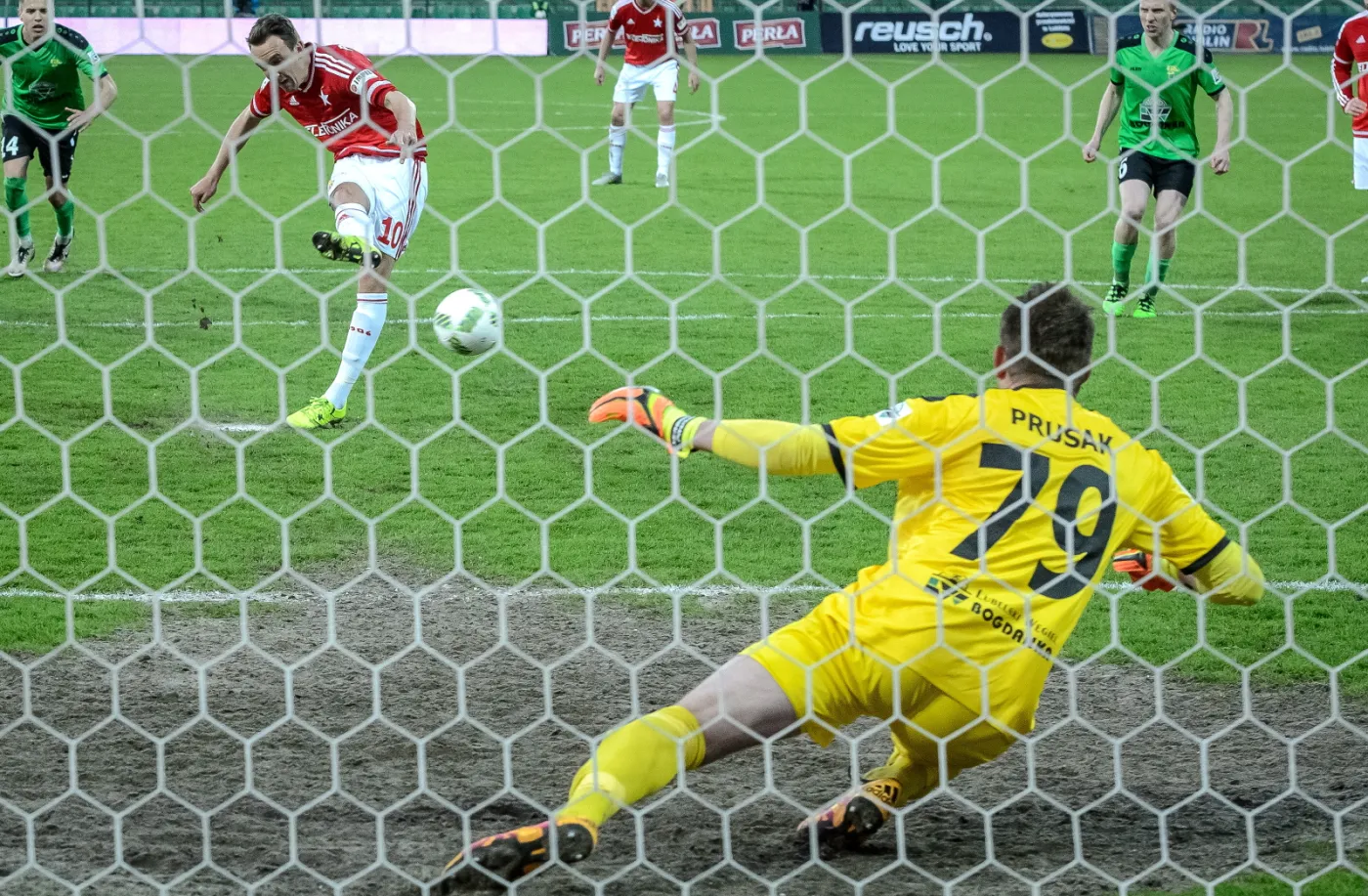 Piłkarz Wisły Kraków Denis Popovic (L) strzela z rzutu karnego na bramkę Sergiusza Prusaka (#79) z Górnika Łęczna podczas meczu grupy spadkowej polskiej Ekstraklasy